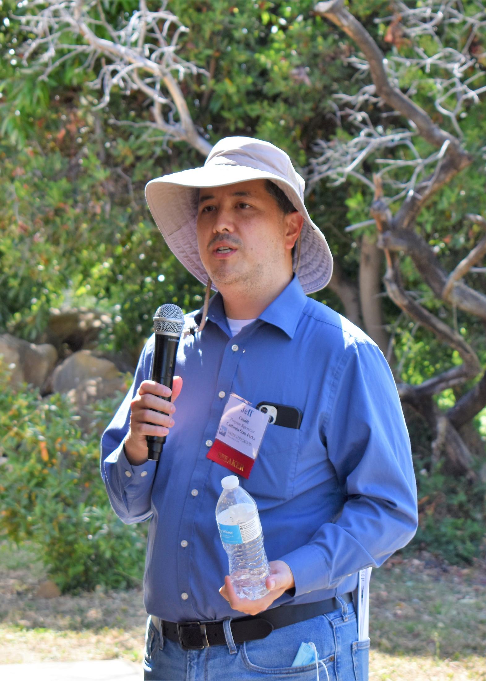 Jeffrey outside holding a microphone